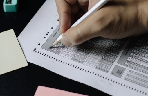 dłoń zakreślająca ołówkiem kratki na kartce papieru